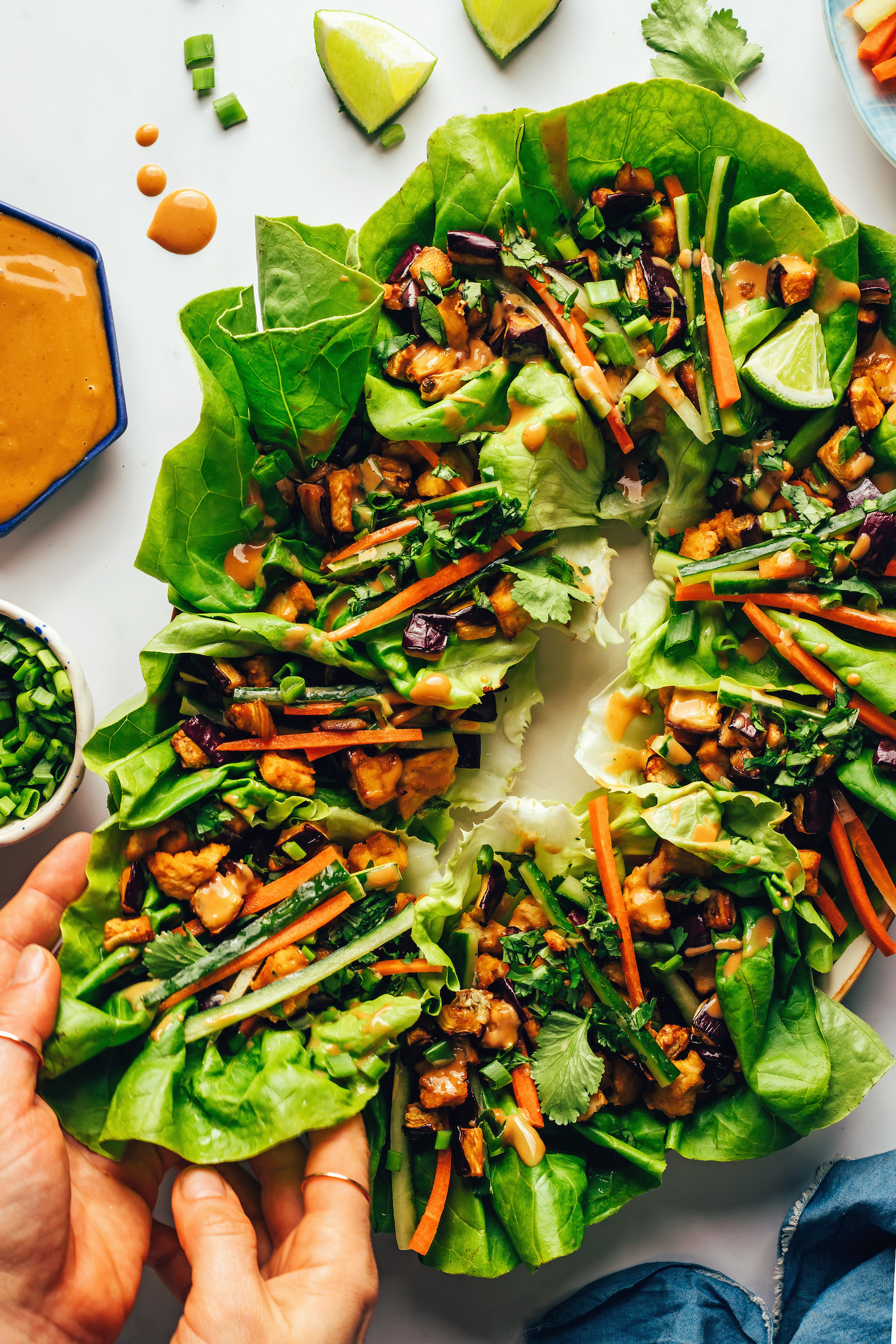 Picking up a crispy tofu and eggplant lettuce cup from a platter