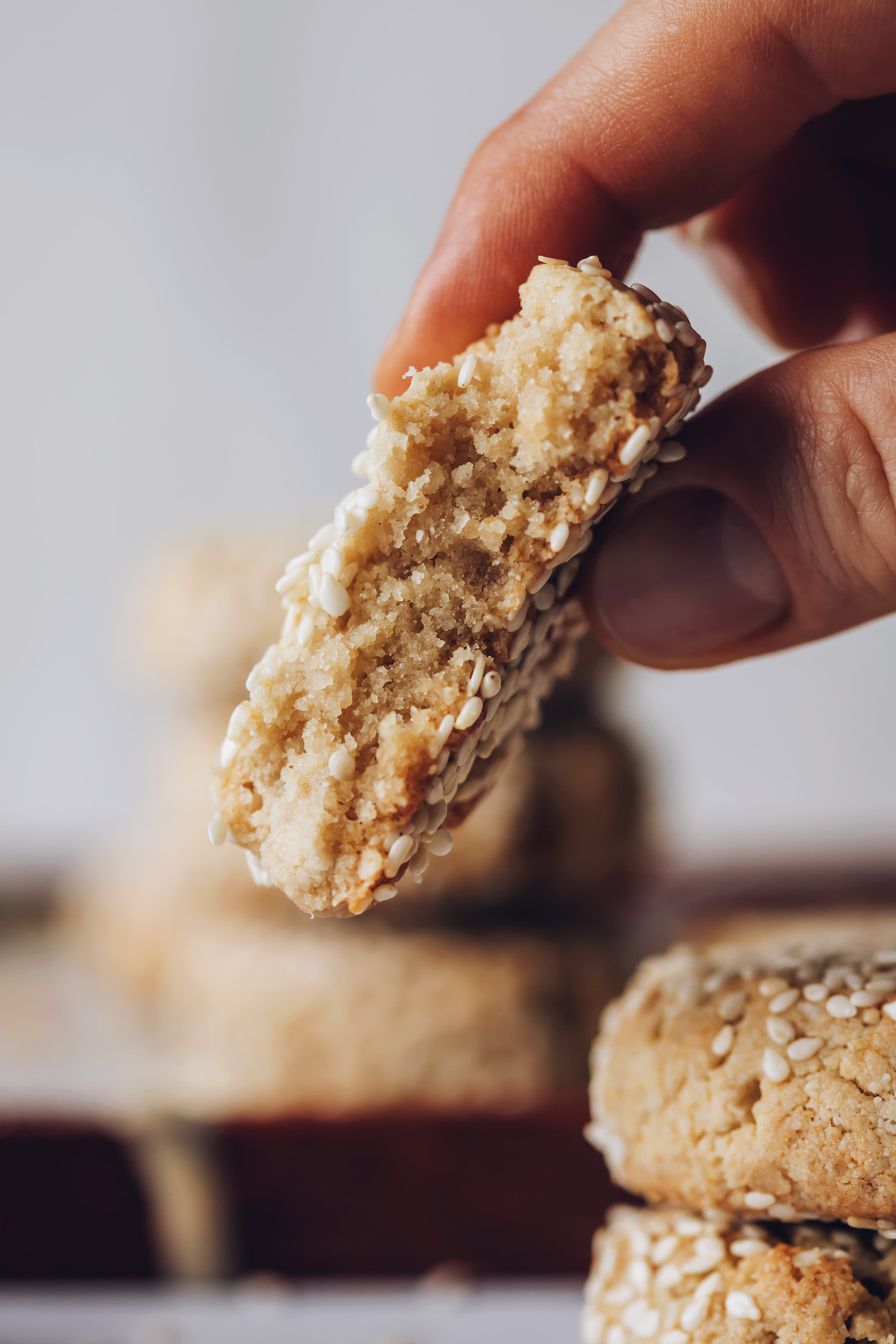 Holding a partially eaten tahini cookie to show the tender center