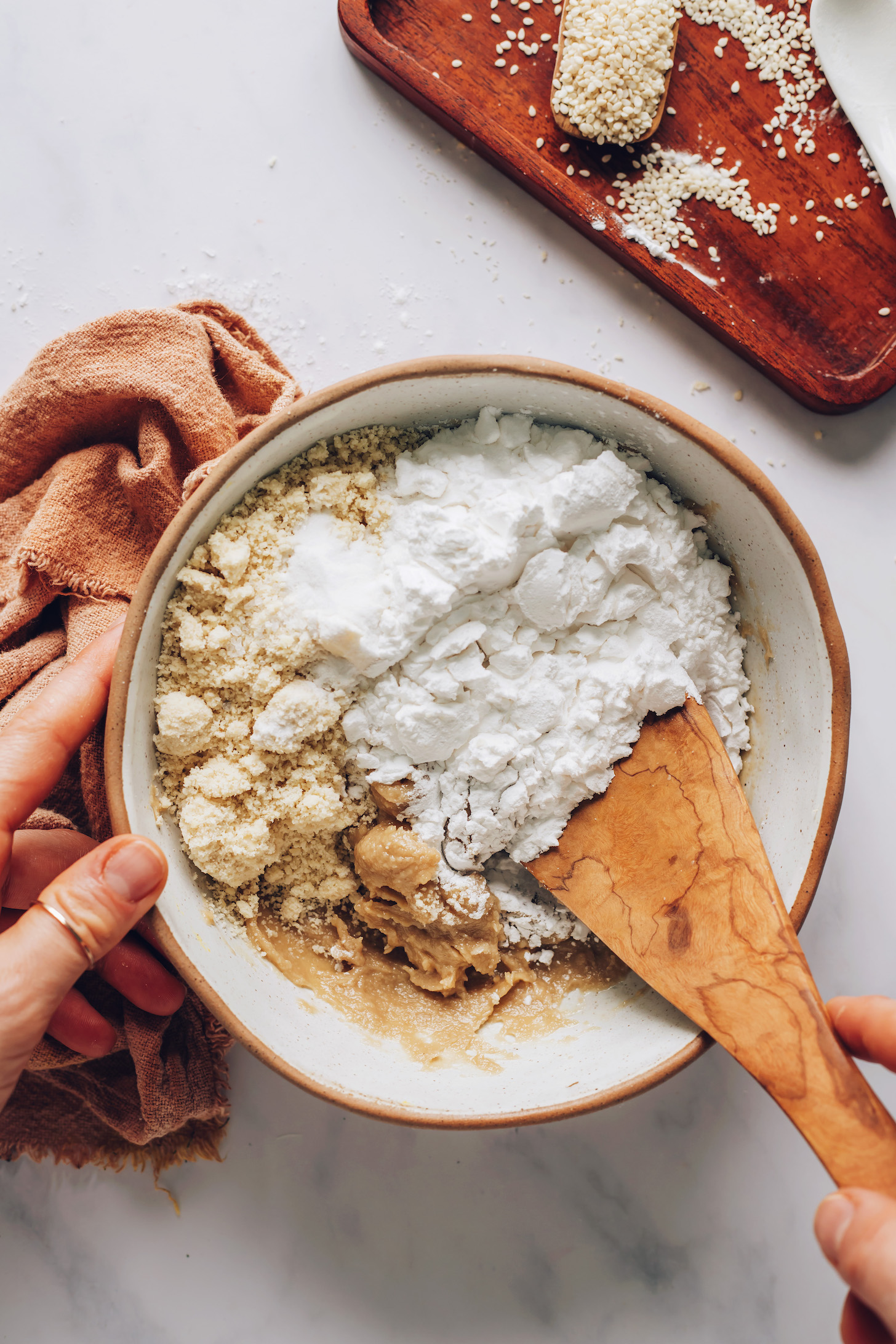 Mixing almond flour and tapioca starch into tahini and maple syrup