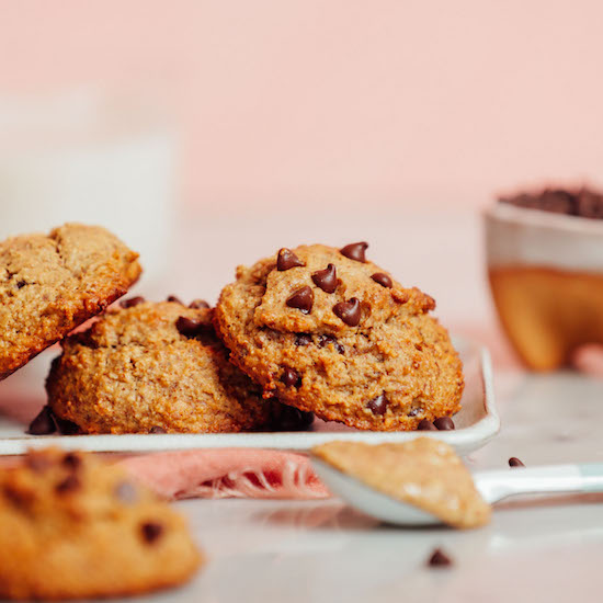 Spoonful of almond butter beside a plate of our 1-Bowl Banana Chocolate Chip Cookies