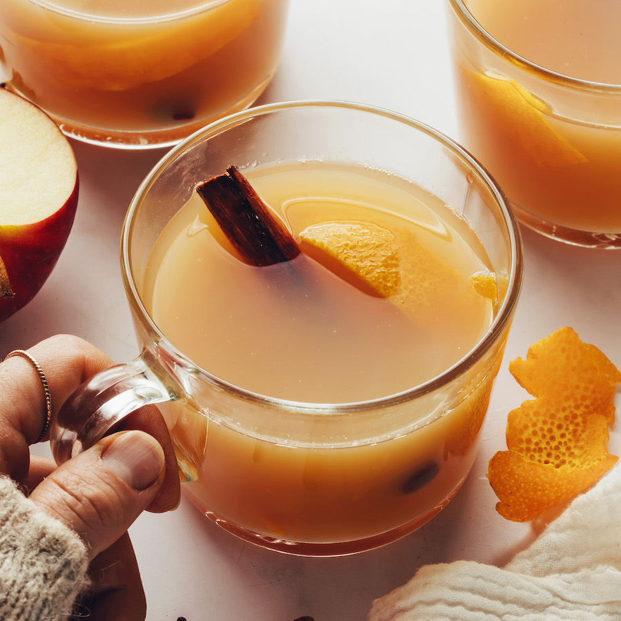 Hand holding a mug of homemade spiced apple cider