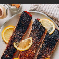 Plate of crispy skin salmon with lemon slices on top