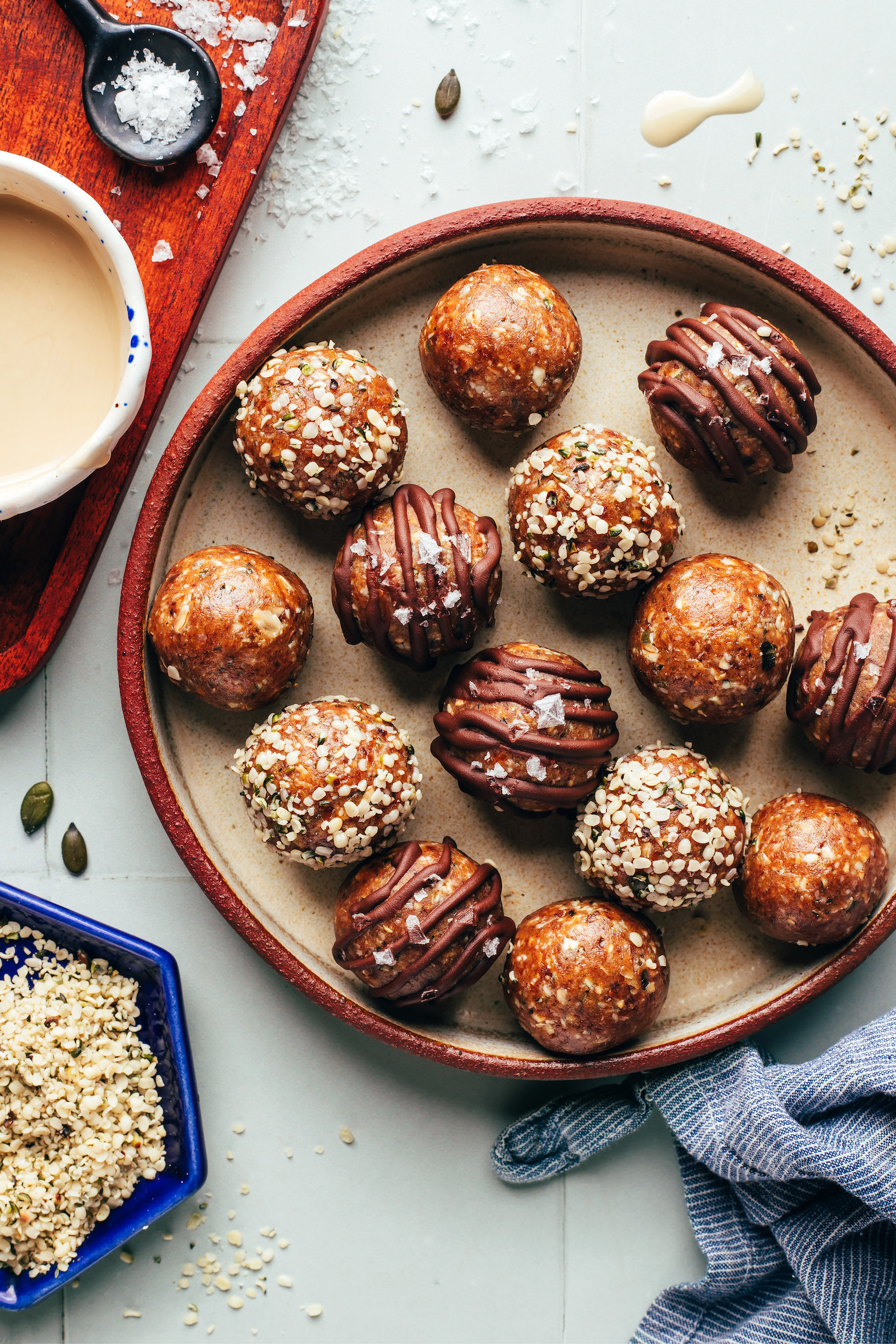 Plate of tahini snack bites with some plain, some rolled in hemp seeds, and some drizzled with chocolate