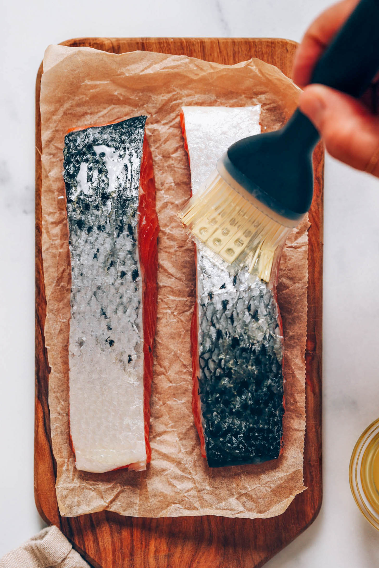 Brushing salmon skin with oil