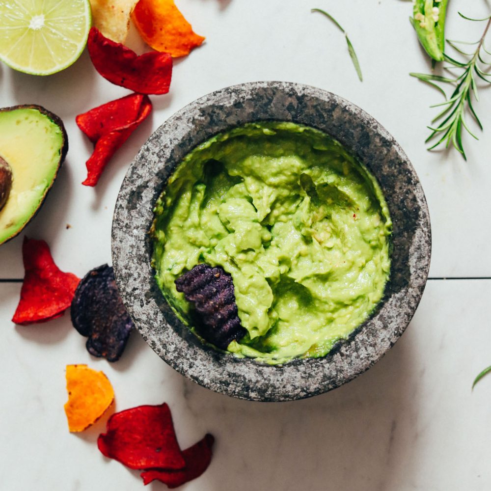 Mortar and pestle of Serrano & Rosemary Guacamole with veggie chips