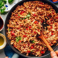 Using a wooden spoon to mix a skillet of our shredded tofu taco meat recipe