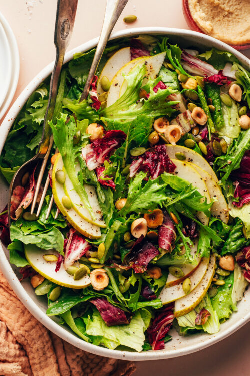 Serving utensils resting in a bowl of our Perfect Thanksgiving Salad recipe