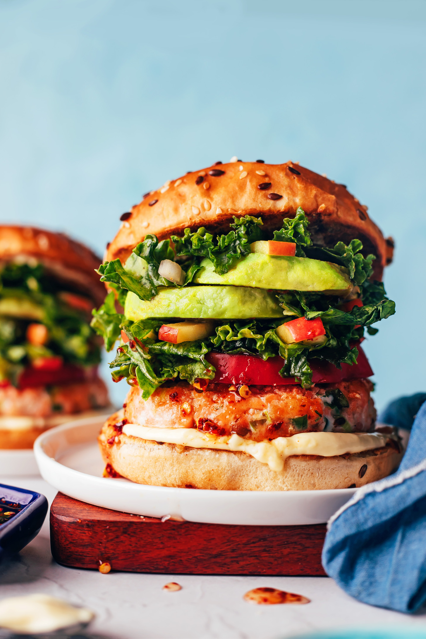 Plates with salmon burgers on buns with toppings