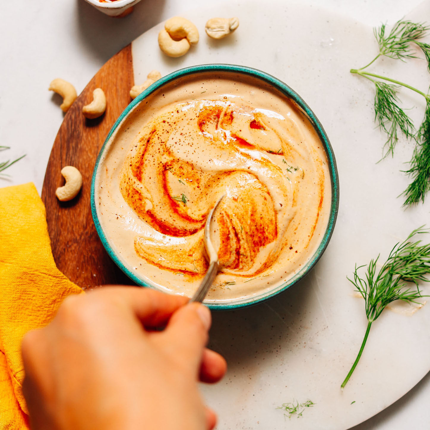 Stirring a bowl of Vegan Chipotle Ranch Dressing