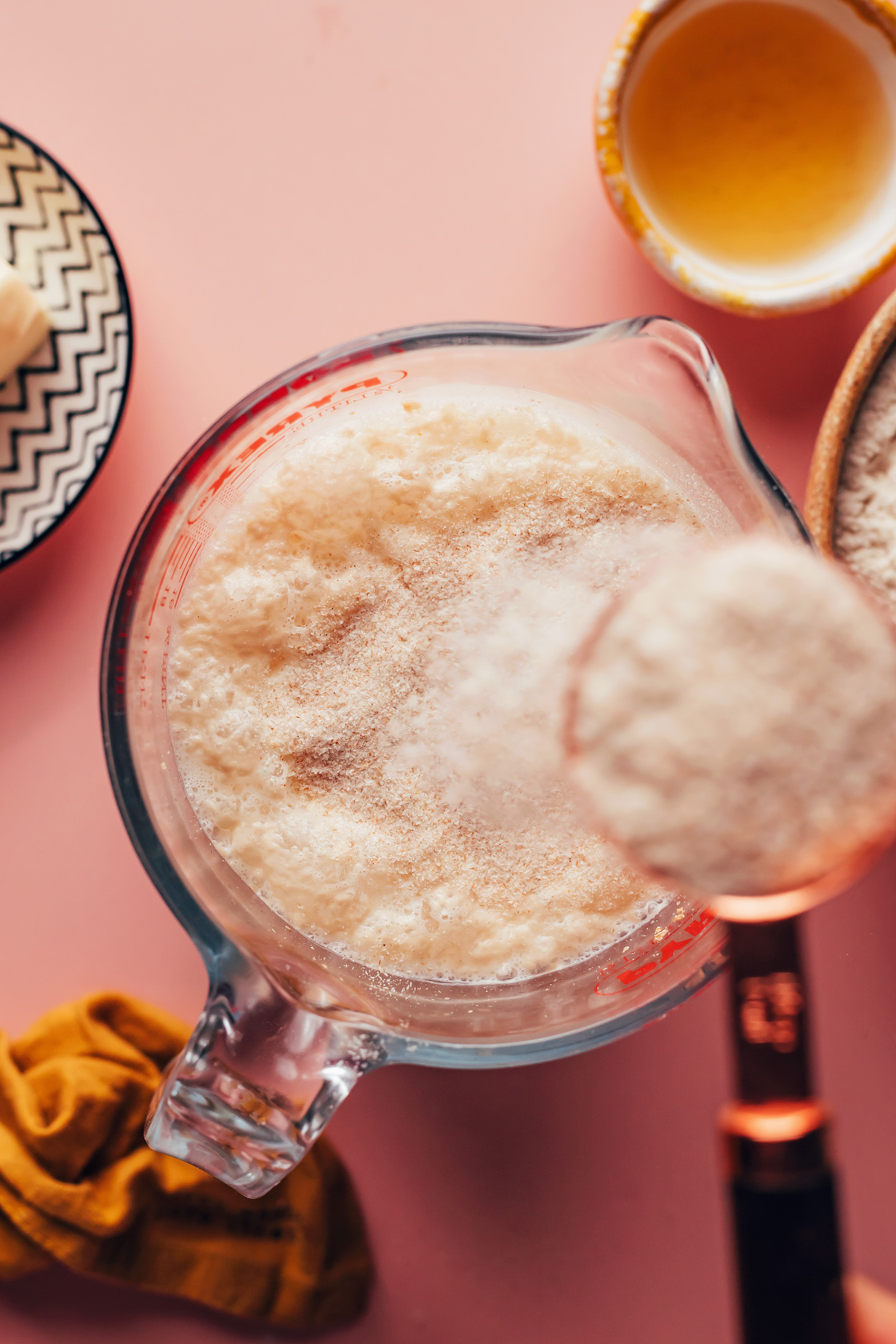 Adding psyllium husk into a measuring glass of activated yeast