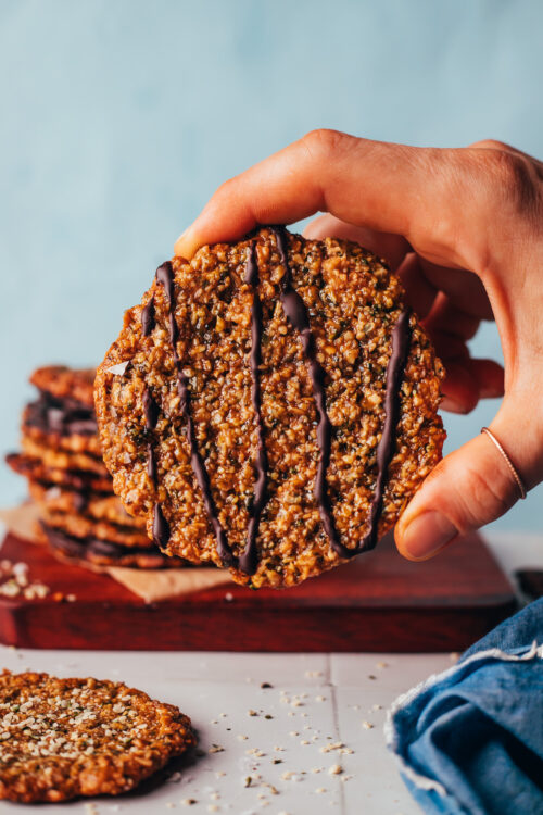 Holding up a florentine cookie decorated with a drizzle of dark chocolate